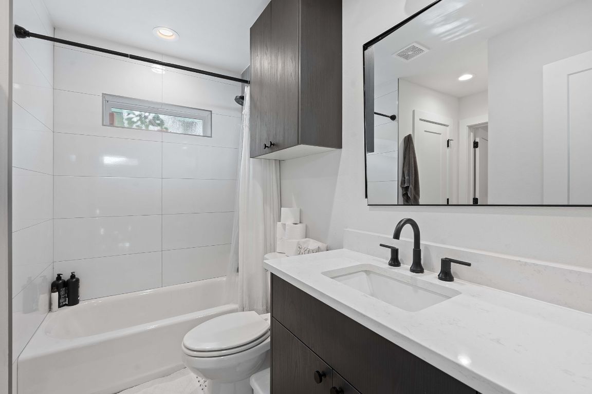 3404 Thomas Kincheon Street, Unit 1 & 3 Austin, TX 78745 - Photo 28 of 30 a bathroom with a sink a toilet and a large mirror