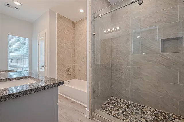 a bathroom with a granite countertop sink a toilet and shower
