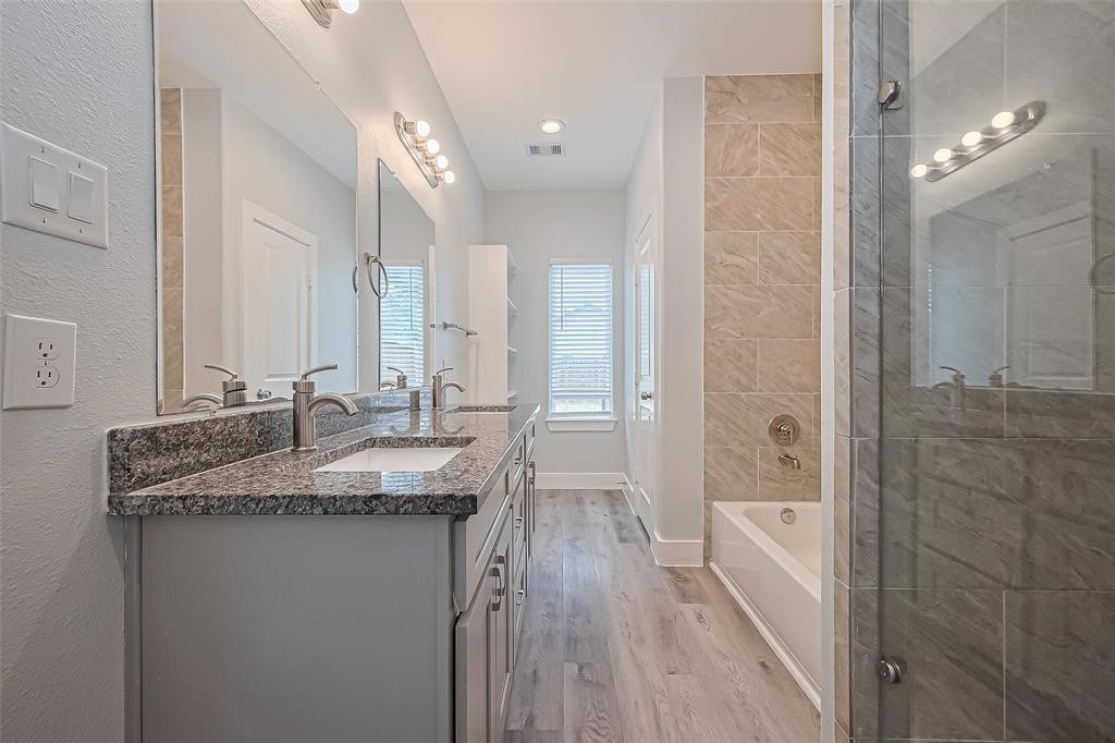 7926 Easter Street Houston, TX 77088 - Photo 22 of 24 a bathroom with a granite countertop sink a mirror and a bathtub