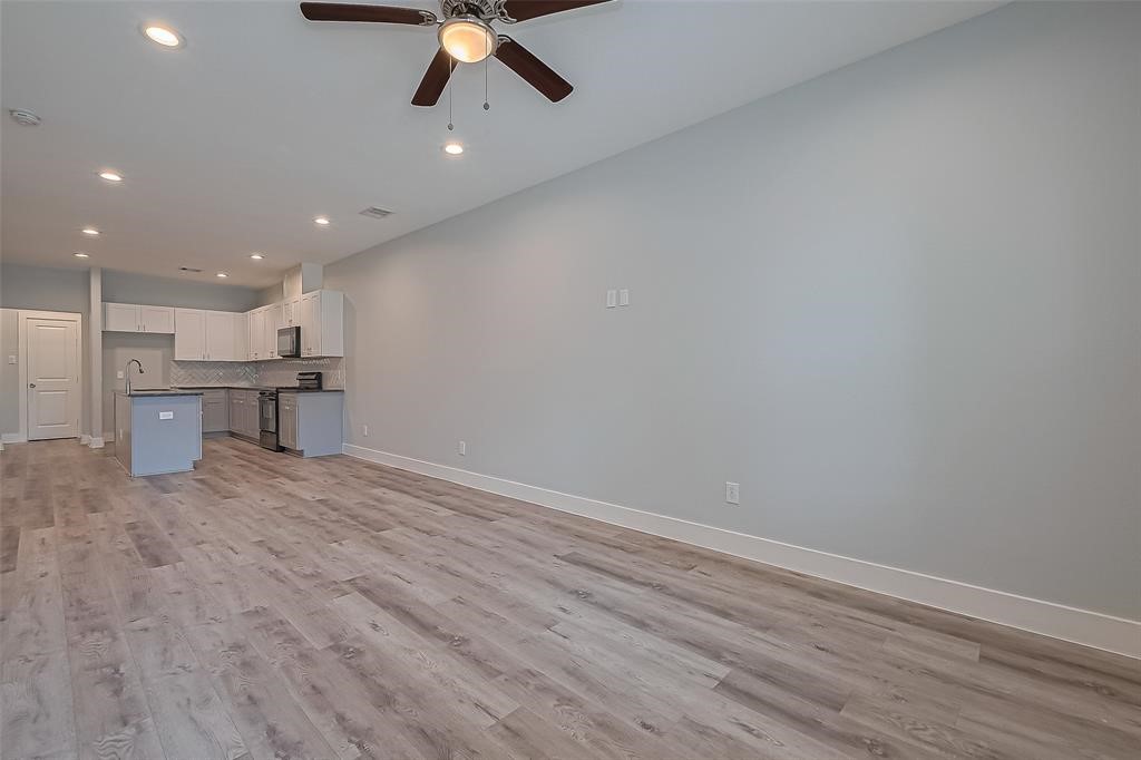 7926 Easter Street Houston, TX 77088 - Photo 6 of 24 an empty room with wooden floor kitchen view and a window