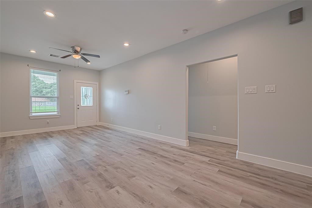 7926 Easter Street Houston, TX 77088 - Photo 7 of 24 an empty room with wooden floor and windows