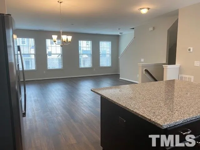 a kitchen with granite countertop a stove and wooden floor
