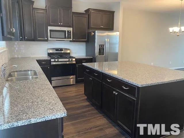 a kitchen with stainless steel appliances granite countertop a sink stove and microwave