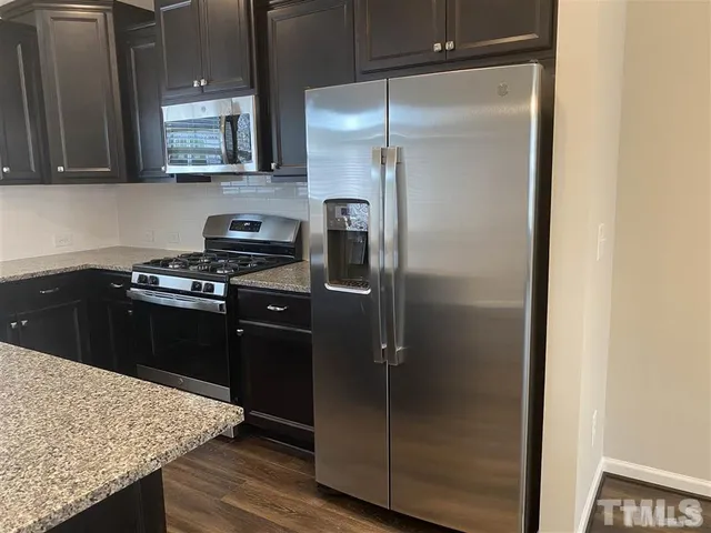 a kitchen with a refrigerator and a stove top oven