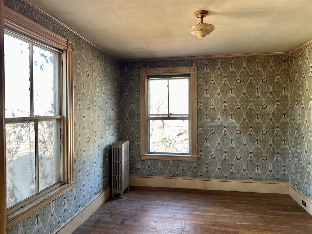 183 Temple Street Boston, MA 02132 - Photo 11 of 15 a view of an empty room with wooden floor and a window