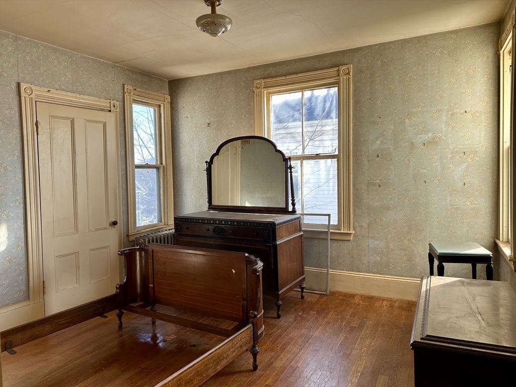 183 Temple Street Boston, MA 02132 - Photo 12 of 15 a living room with a bed furniture and a window