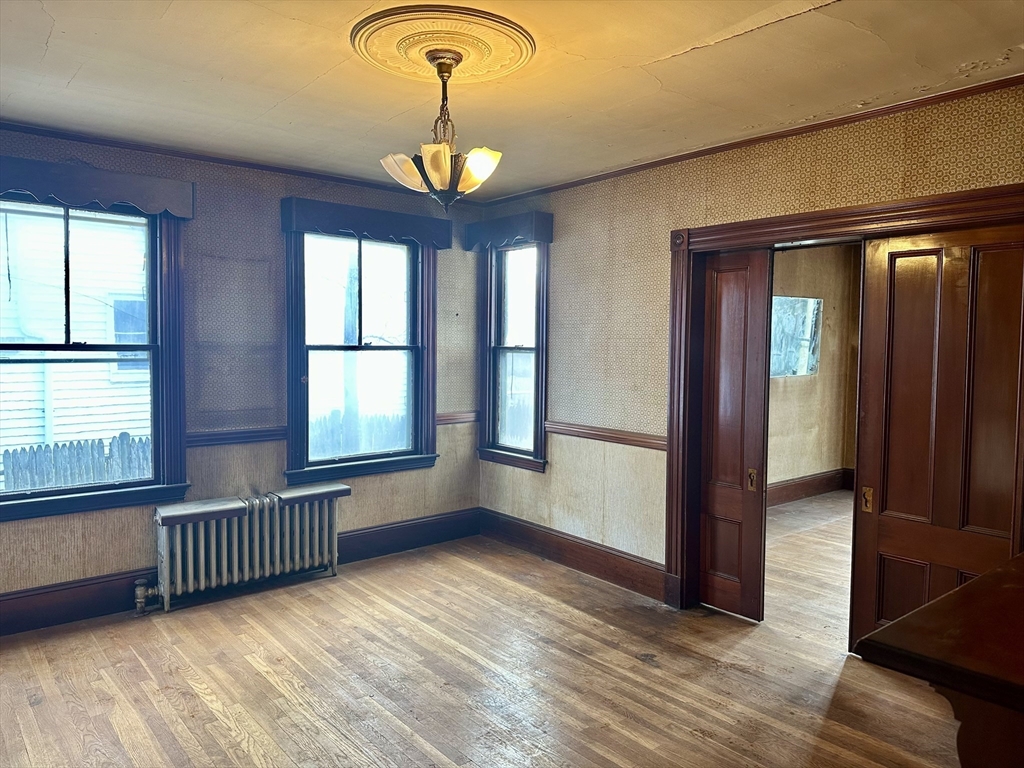 183 Temple Street Boston, MA 02132 - Photo 7 of 15 a view of an empty room with a window and wooden floor