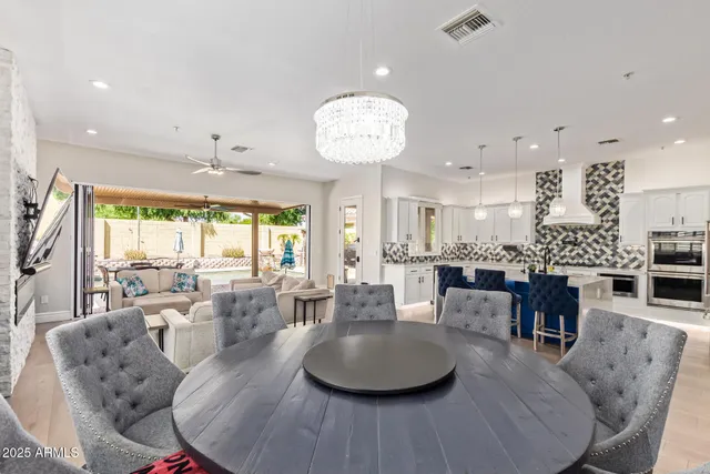 a kitchen with stainless steel appliances kitchen island granite countertop a table and chairs in it