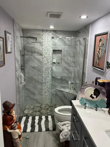 a bathroom with a sink a toilet and shower