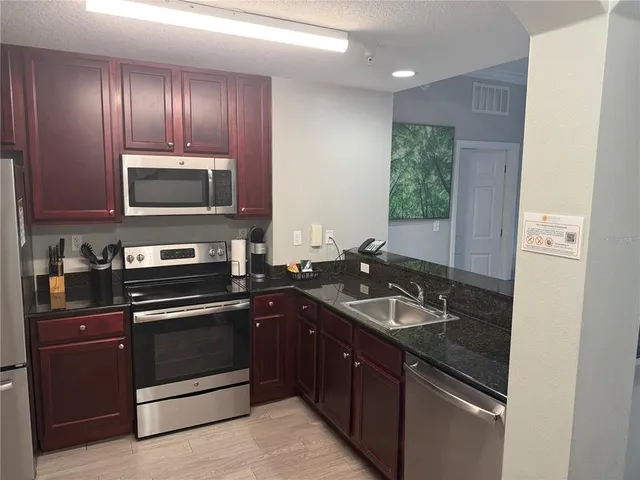 a kitchen with wooden cabinets and stainless steel appliances