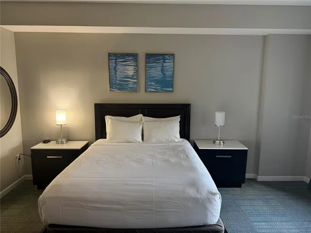 a bedroom with a bed and a flat tv screen on dresser