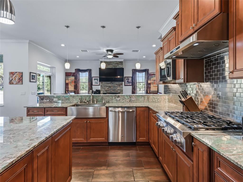 19331 East Levy Street Williston, FL 32696 - Photo 17 of 81 a kitchen with stainless steel appliances granite countertop a stove top oven a sink dishwasher a dining table and chairs