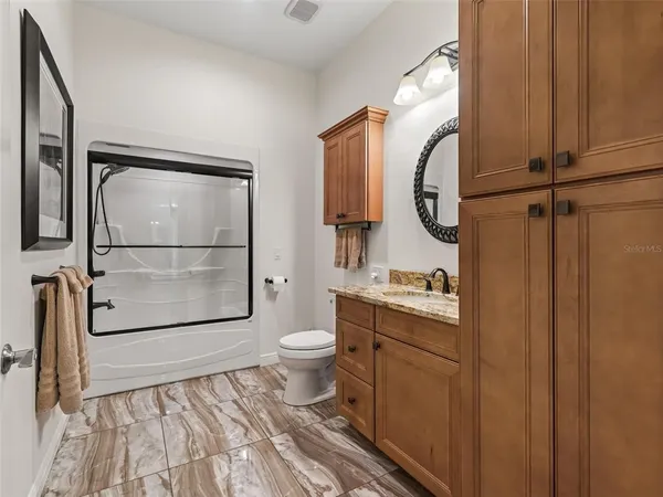 a bathroom with a sink a toilet and shower