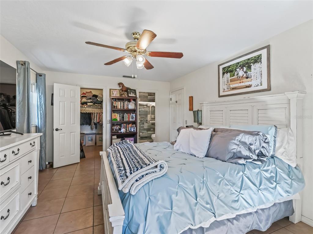 19331 East Levy Street Williston, FL 32696 - Photo 50 of 81 a bedroom with a large bed and a flat tv screen