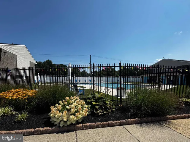 a view of a garden with a flower garden in the background