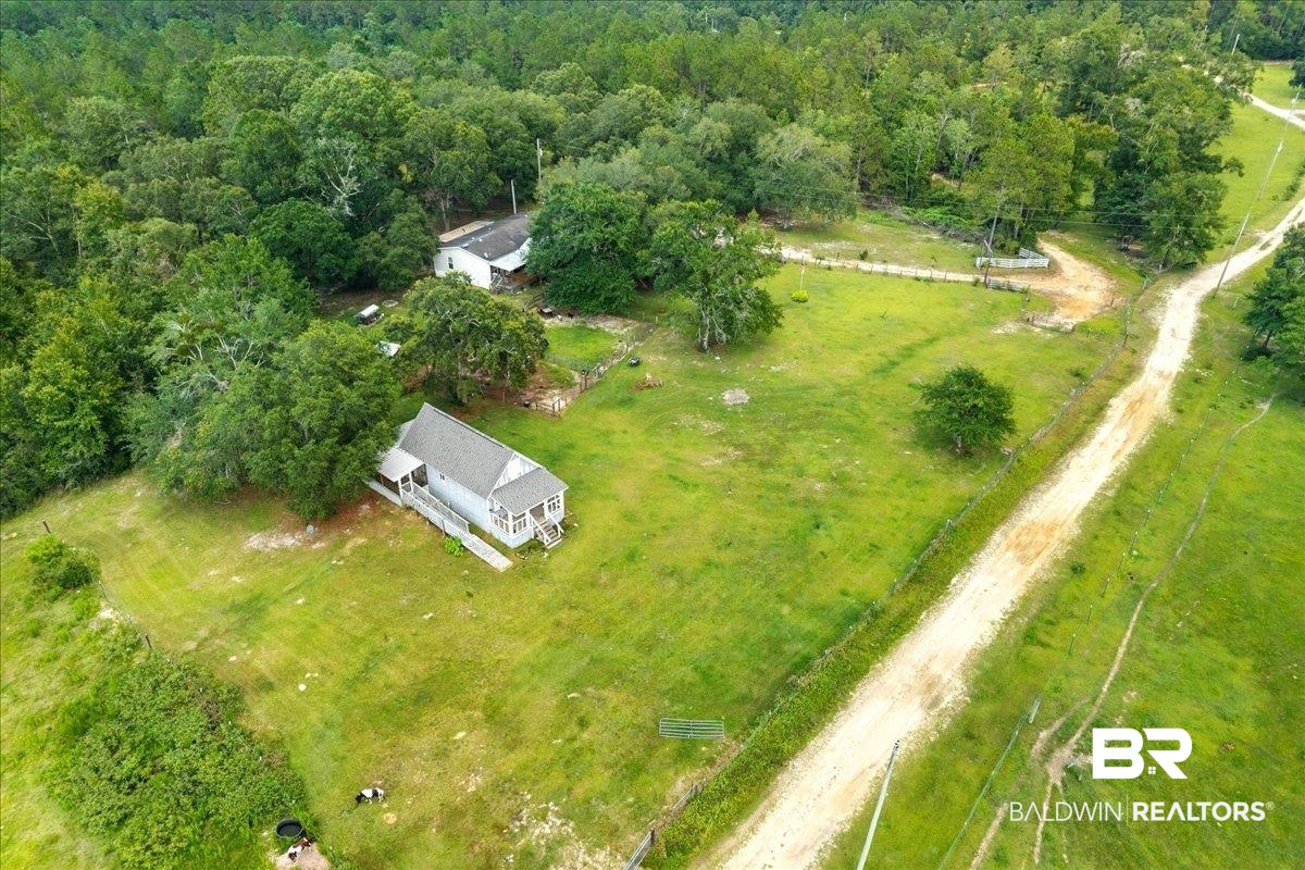 21011 River Road Robertsdale, AL 36567 - Photo 25 of 29 Expansive property featuring a residence with a covered porch and an additional structure, surrounded by mature trees and open green spaces
