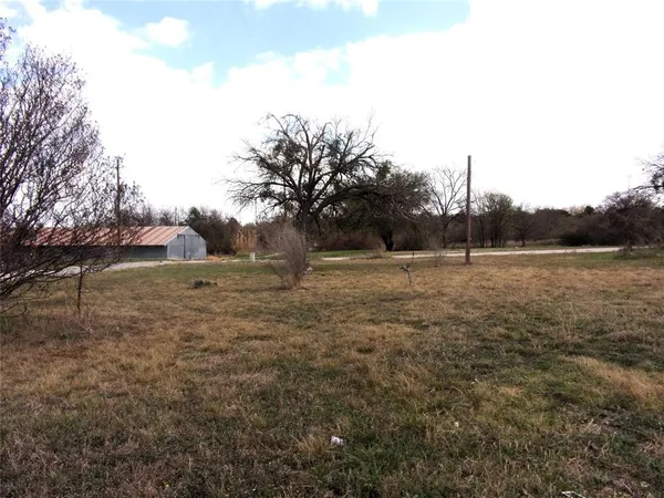 a view of a field with trees in the background