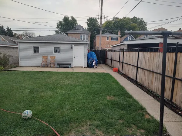 a view of a backyard with sitting area and garage