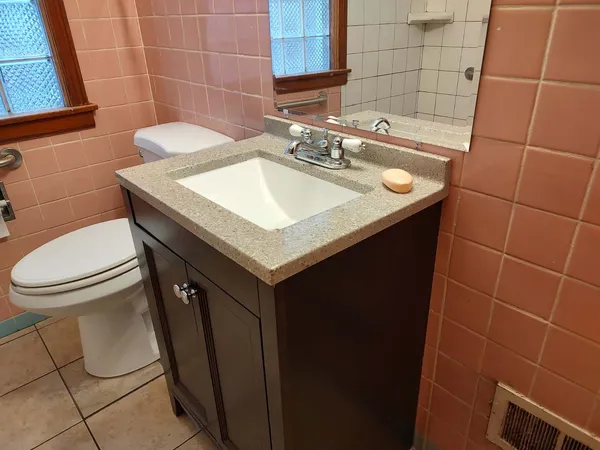a bathroom with a sink toilet and a mirror