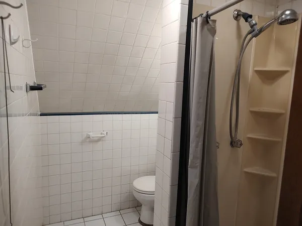 a bathroom with a granite countertop toilet and a shower