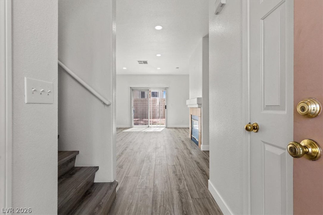 1412 Beaver Spring Street Las Vegas, NV 89128 - Photo 20 of 20 Enter into a bright, open floorplan with durable flooring and a cozy fireplace, leading to outdoor access.