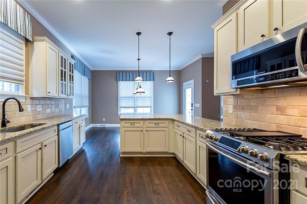 535 Fourth Baxter Crossing Fort Mill, SC 29708 - Photo 4 of 23 a kitchen with stainless steel appliances a stove cabinets and wooden floor