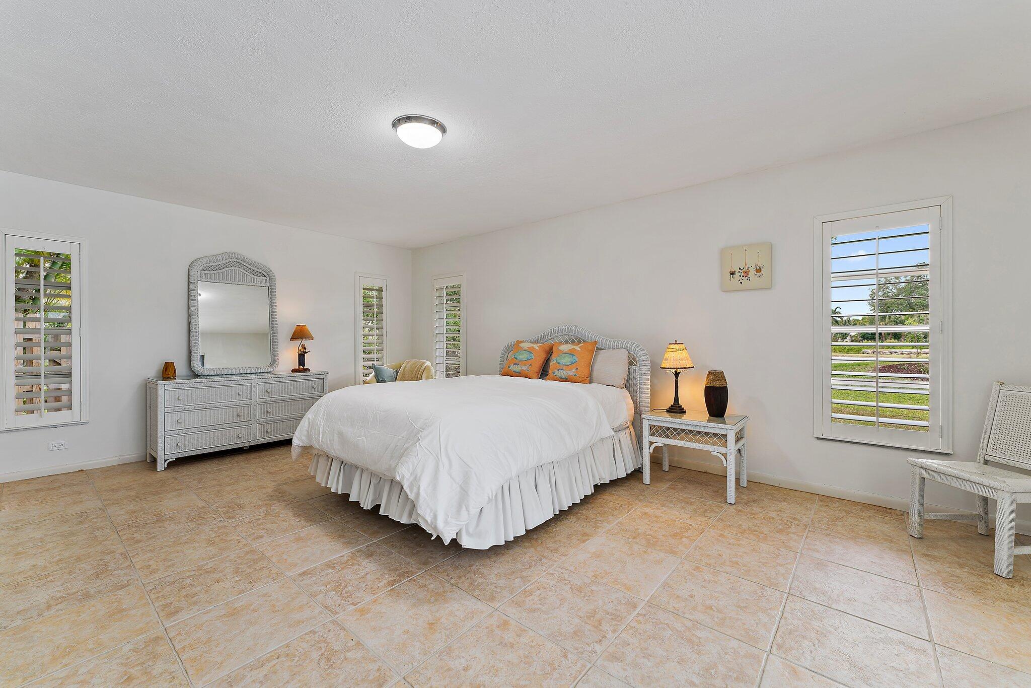 80 Southeast Turtle Creek Drive Jupiter, FL 33469 - Photo 14 of 23 a bed room with a bed and a chair