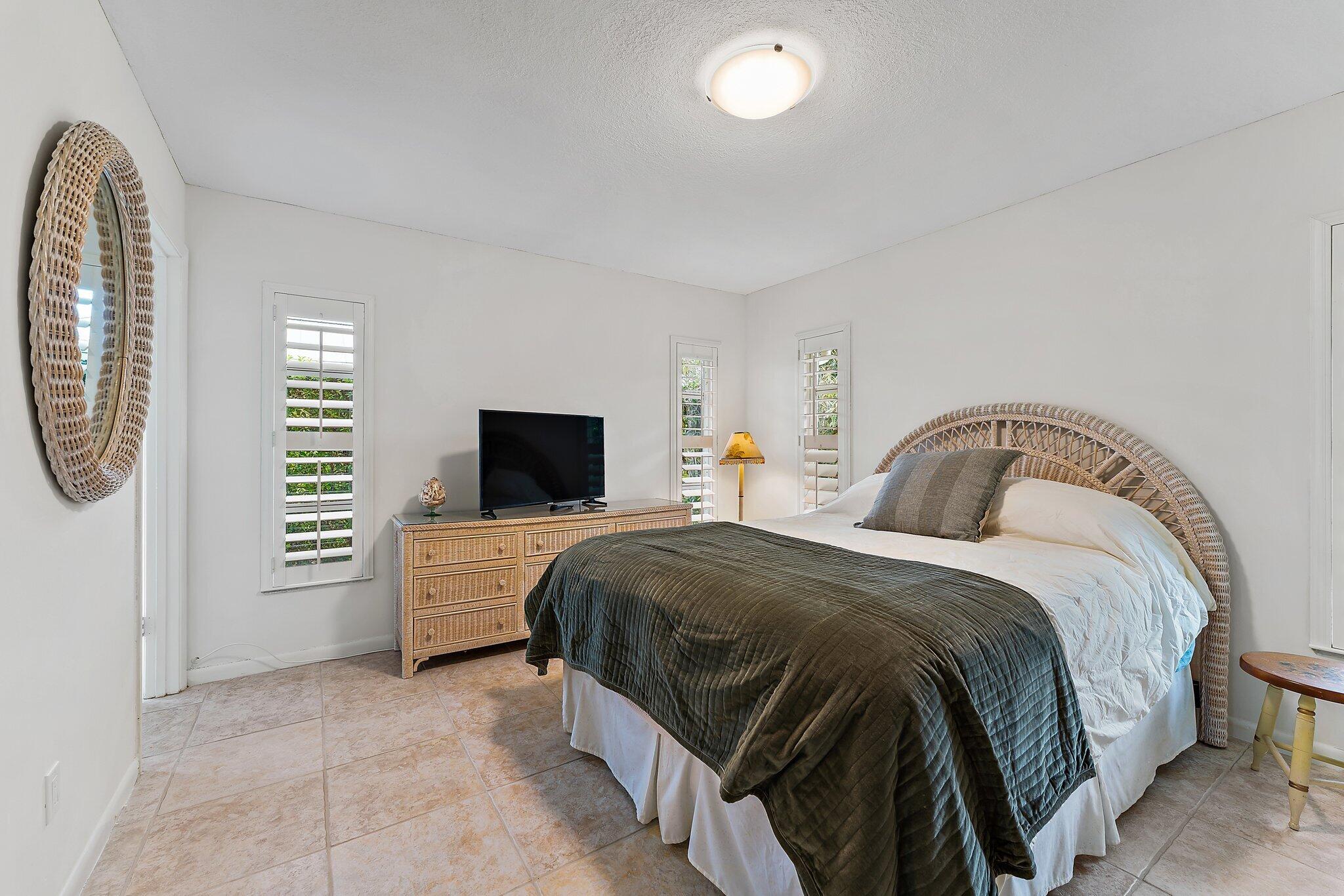 80 Southeast Turtle Creek Drive Jupiter, FL 33469 - Photo 16 of 23 a bedroom with a bed and a television