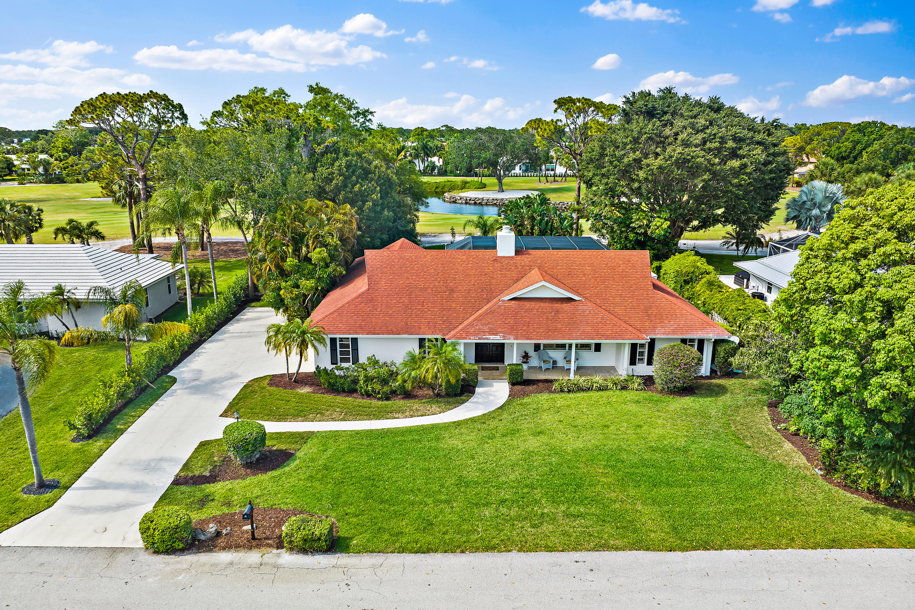 80 Southeast Turtle Creek Drive Jupiter, FL 33469 - Photo 2 of 23 a aerial view of a house with garden space and street view