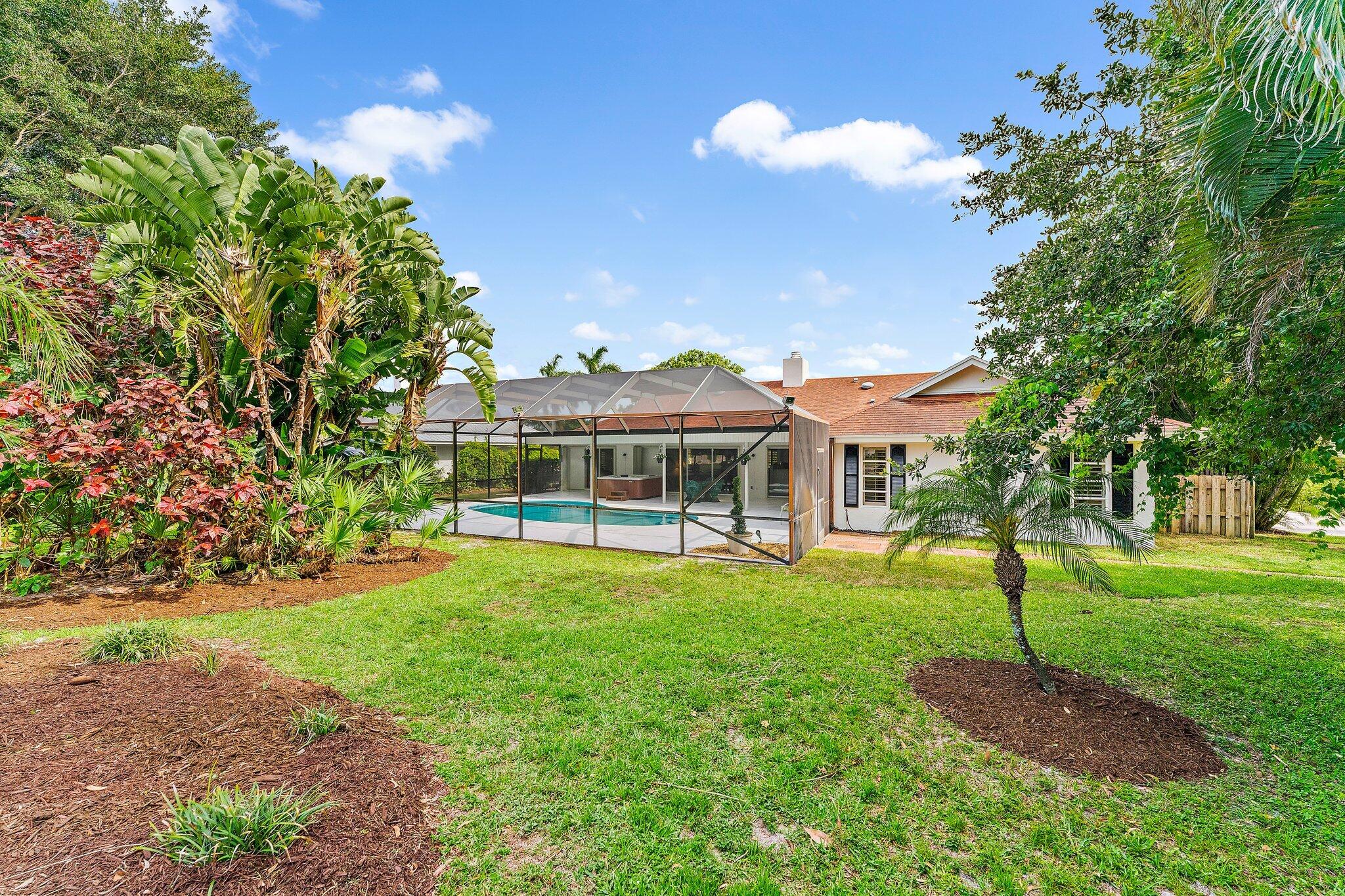 80 Southeast Turtle Creek Drive Jupiter, FL 33469 - Photo 22 of 23 a front view of a house with a garden