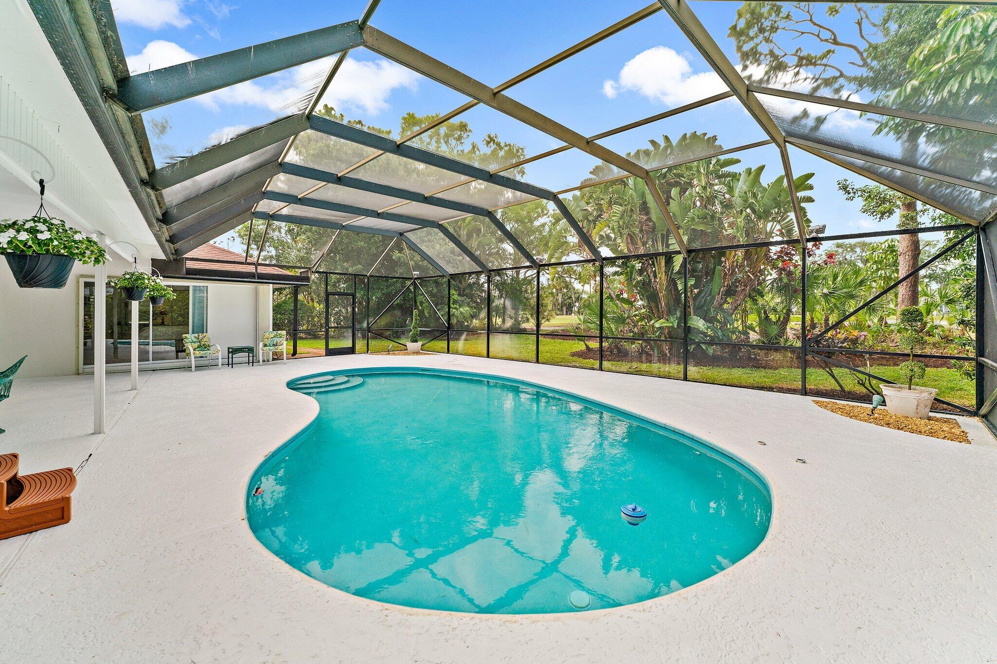 80 Southeast Turtle Creek Drive Jupiter, FL 33469 - Photo 6 of 23 a view of a swimming pool with a yard and sitting area