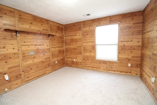 en empty room with a window and a ceiling fan