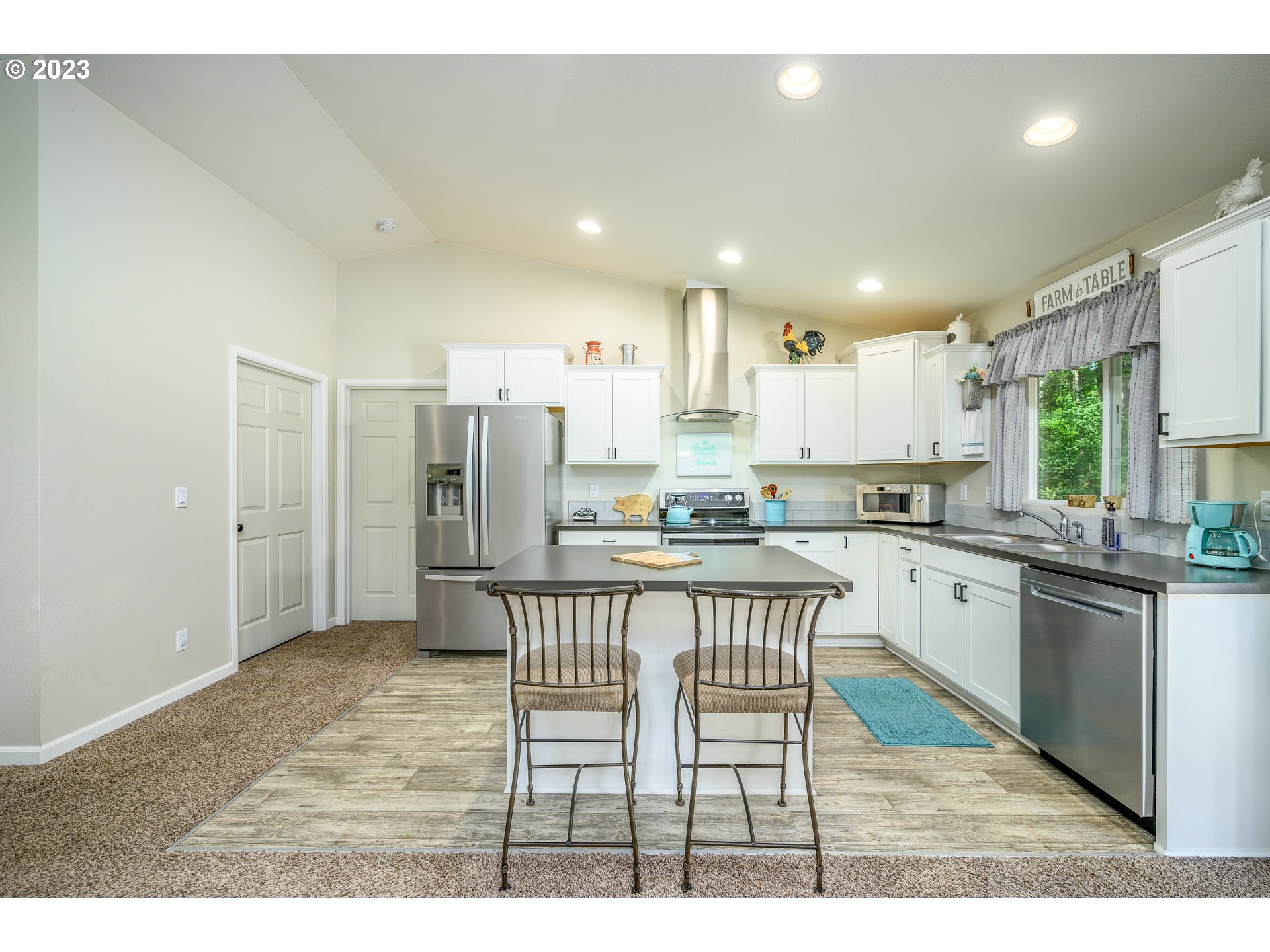 7297 Ash Street Grand Ronde, OR 97347 - Photo 12 of 33 a kitchen with stainless steel appliances kitchen island granite countertop a refrigerator a stove a sink a dining table and chairs