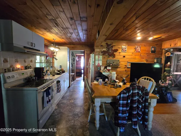 a kitchen with granite countertop lots of wooden furniture and stainless steel appliances