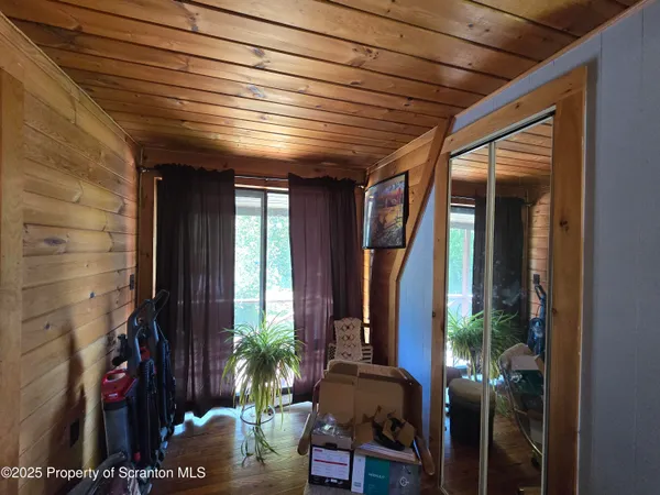 a view of living room filled with furniture and floor to ceiling window and potted plants
