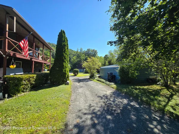 a view of a house with a yard and tree s