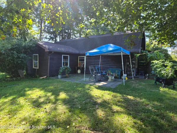 a view of a chair and table in backyard of the house