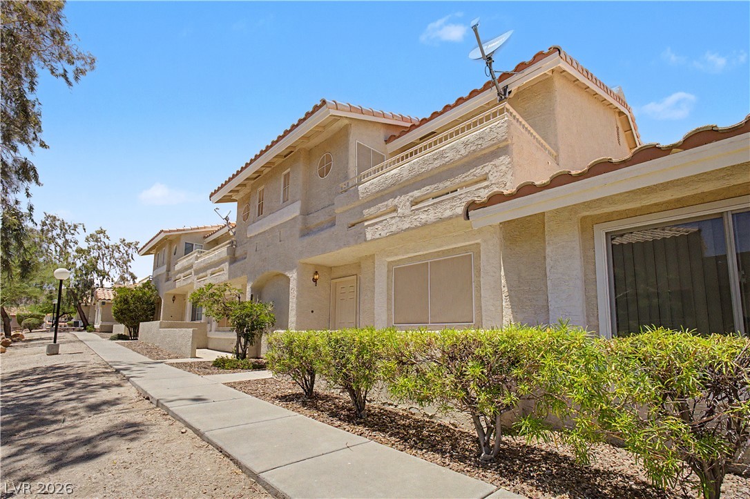 2243 Rugged Mesa Drive Laughlin, NV 89029 - Photo 2 of 32 Discover a charming stucco exterior with tile roofing, accented by well-maintained landscaping and accessible sidewalks.
