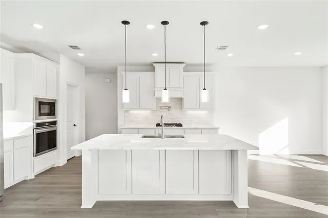 a kitchen with kitchen island a counter top space appliances and a center island