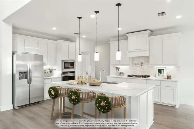 a kitchen with stainless steel appliances granite countertop a stove a sink a refrigerator a center island a dining table and chairs