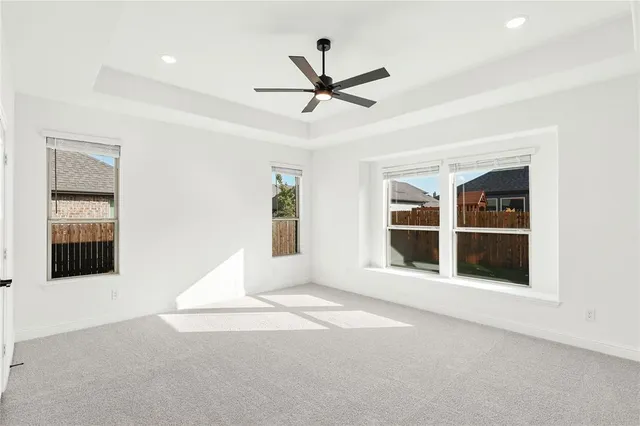 a view of an empty room with a window and kitchen view