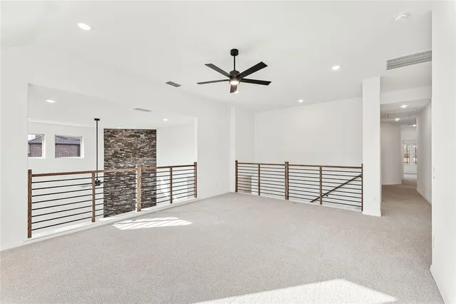 en empty room with windows and ceiling fan