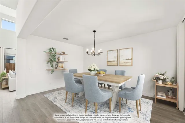 a dining room with furniture wooden floor a rug and a chandelier