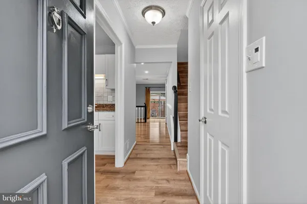 a view of a hallway with wooden floor and staircase