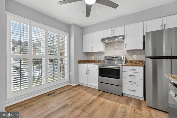 a kitchen with white cabinets and white stainless steel appliances