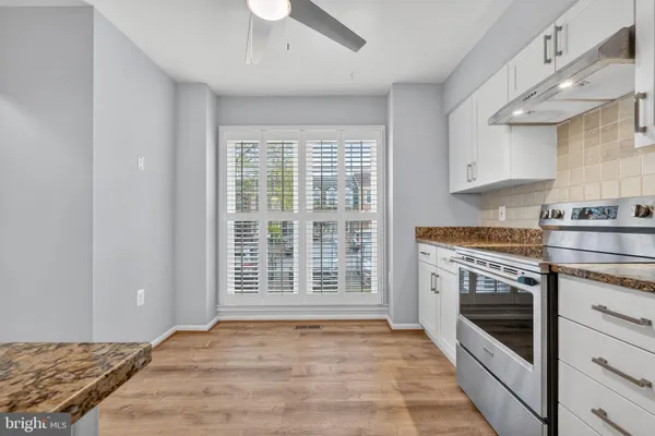 a open kitchen with granite countertop a stove top oven a sink and a counter space