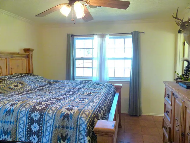 a bedroom with a bed and a flat tv screen on dresser