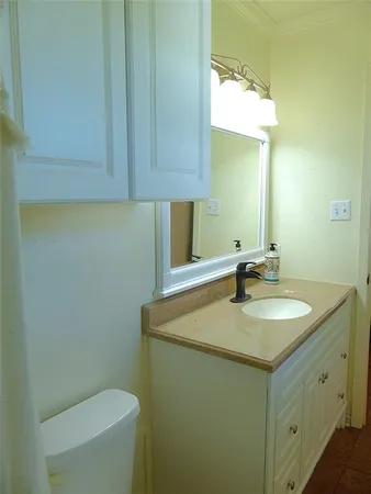 a bathroom with a granite countertop sink a toilet and a mirror