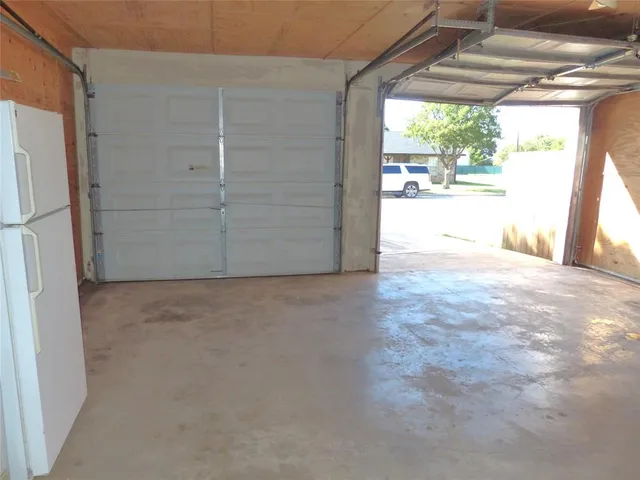 a view of empty room with window and refrigerator