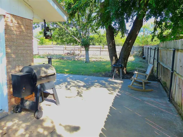 a view of a backyard with furniture and a tree